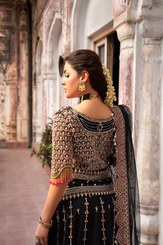 Woman in traditional attire standing in front of an architectural structure