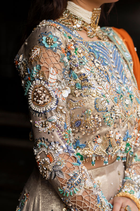 Close-up of a person wearing an intricately designed blouse with embroidery and embellishments.