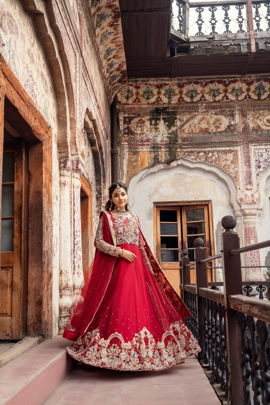 Woman in a red traditional outfit standing in an ornate architectural setting
