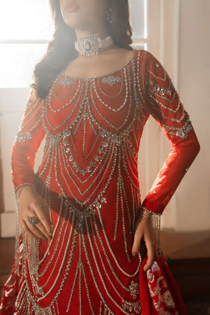 Red dress with intricate silver detailing worn by a person.