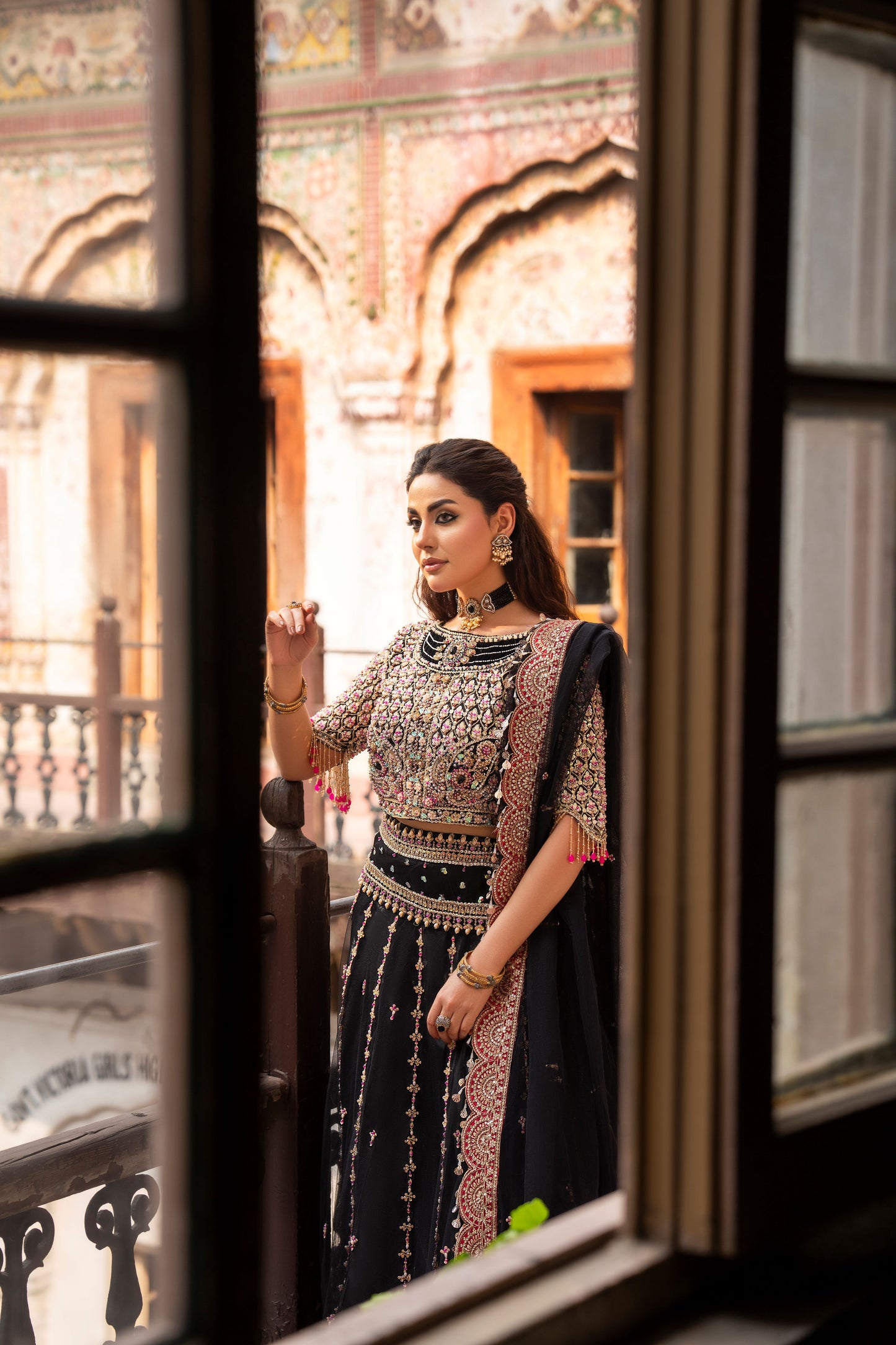 Woman in traditional attire standing in front of a decorative door.