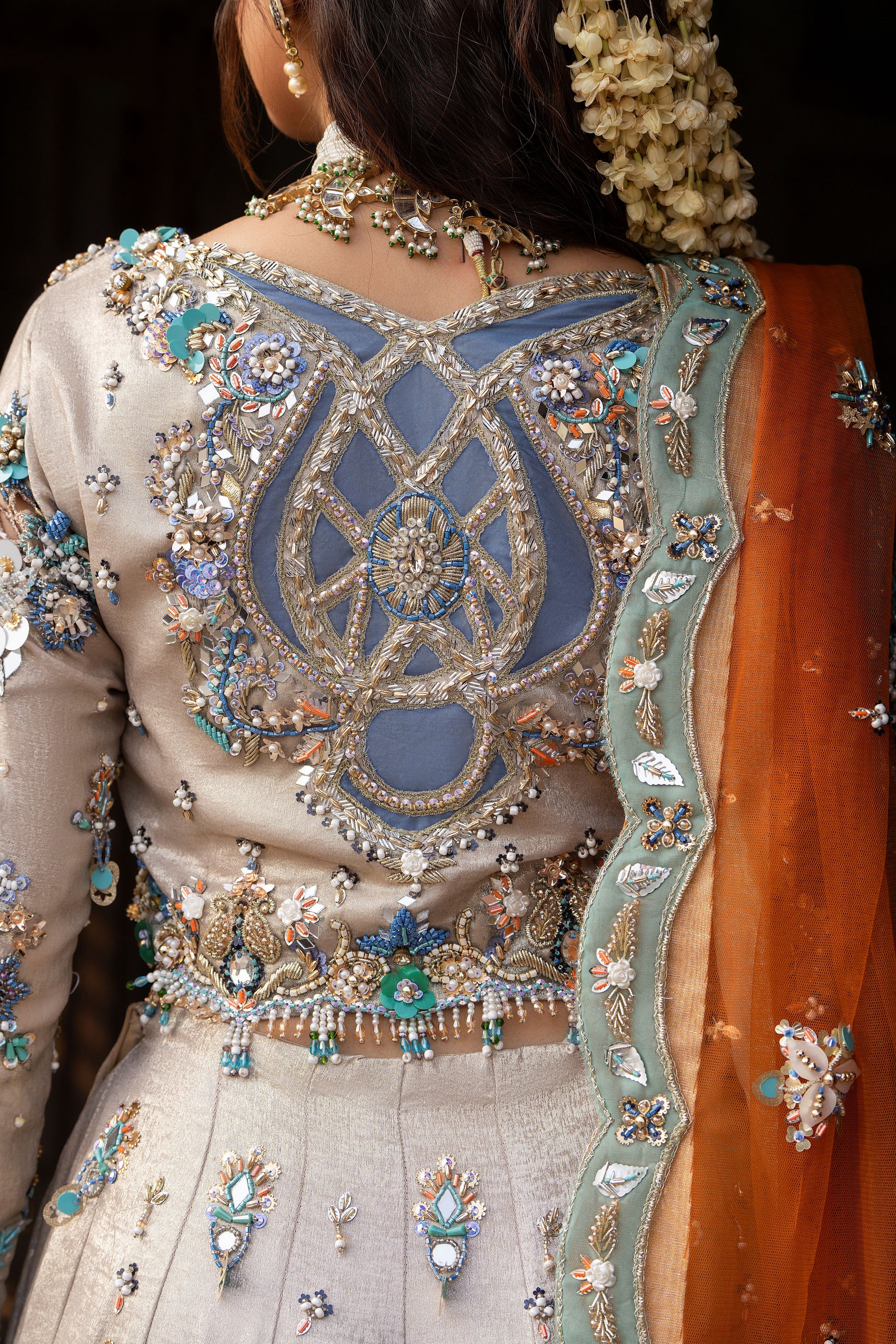 Close-up of a person wearing an intricately embroidered traditional outfit with a focus on the back design.